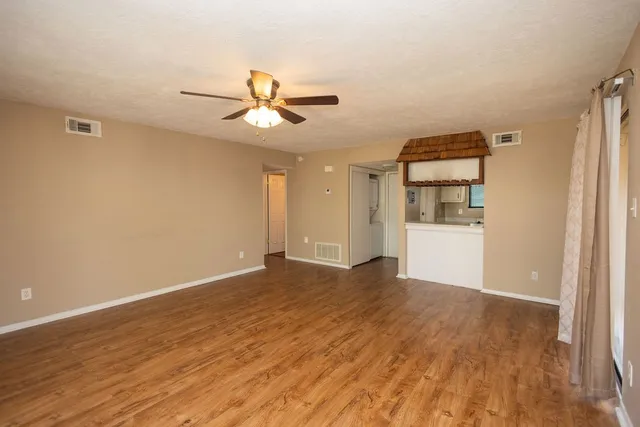 a view of a livingroom with wooden floor and a ceiling fan