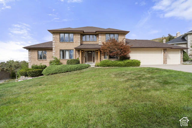 1373 Pheasant Ridge Circle Bountiful, UT 84010 - Photo 2 of 50 Brick exterior with multiple large windows, a prominent entrance, a two-car garage, and established front landscaping