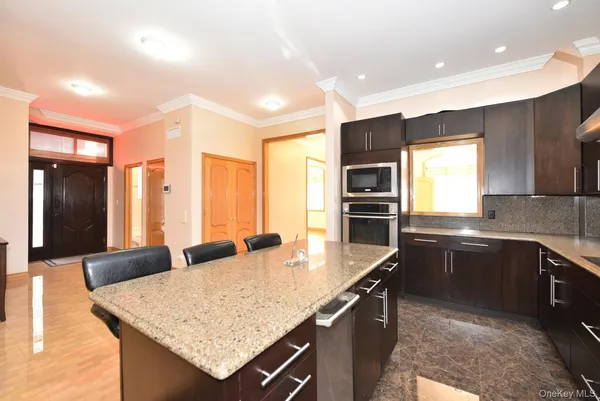 a kitchen with stainless steel appliances granite countertop a sink and a refrigerator