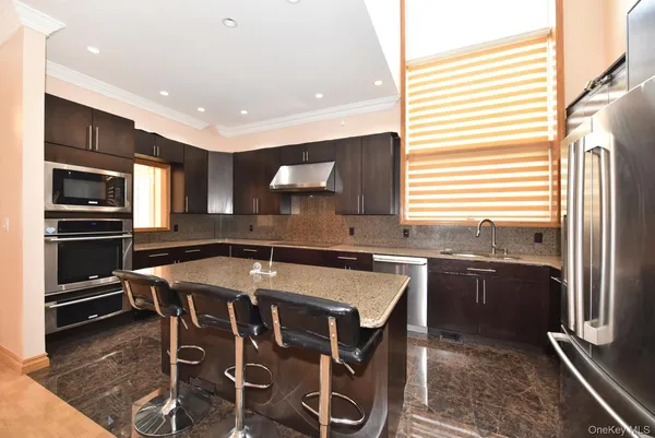a kitchen with stainless steel appliances granite countertop a stove a sink and a refrigerator