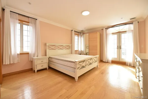 a bedroom with a bed lamp and windows