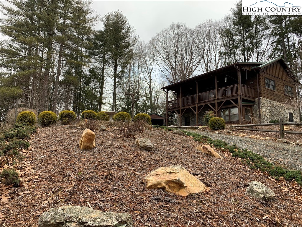 447 South Turkey Ridge Crumpler, NC 28617 - Photo 3 of 39 a backyard of a house with garden and outdoor seating