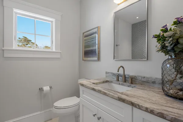 a bathroom with a shower sink vanity mirror and toilet