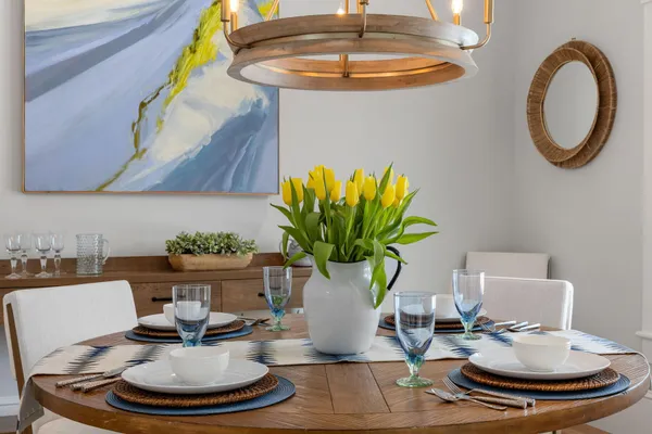 a kitchen with granite countertop a stove a sink a dining table and chairs with wooden floor