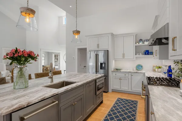 a kitchen with stainless steel appliances granite countertop a refrigerator sink and white cabinets