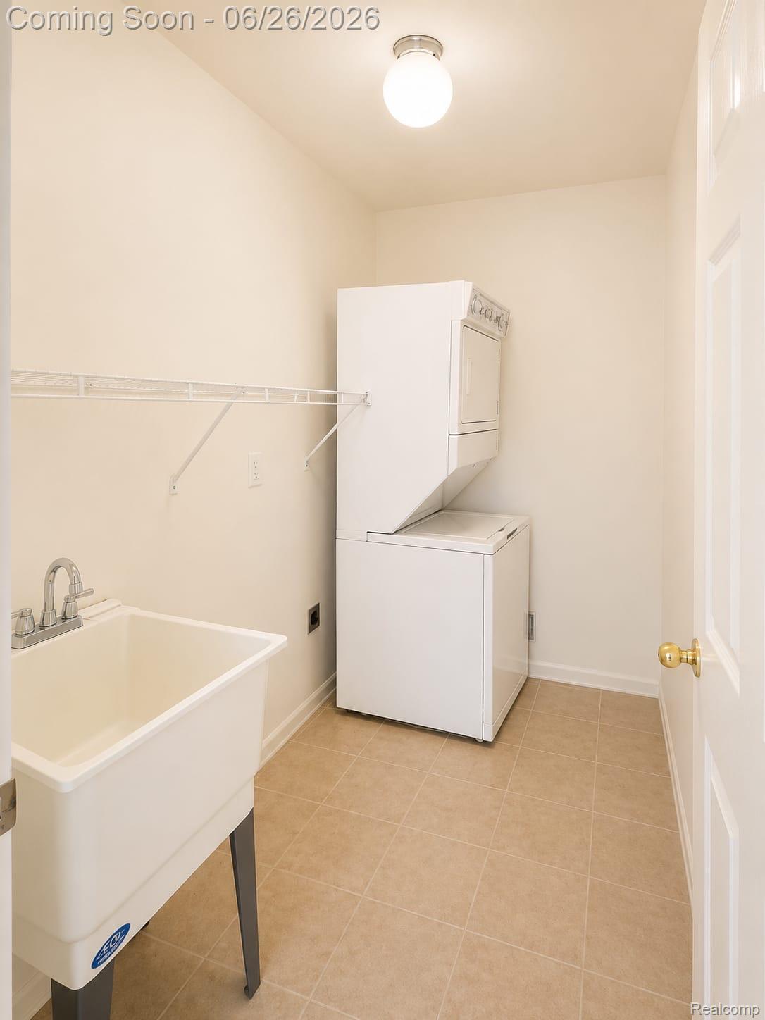 17014 Country Ridge Lane Macomb, MI 48044 - Photo 5 of 25 Utility room featuring a utility sink, a stacked washer and dryer unit, tiled flooring, a wire shelf, and a flush mount light fixture