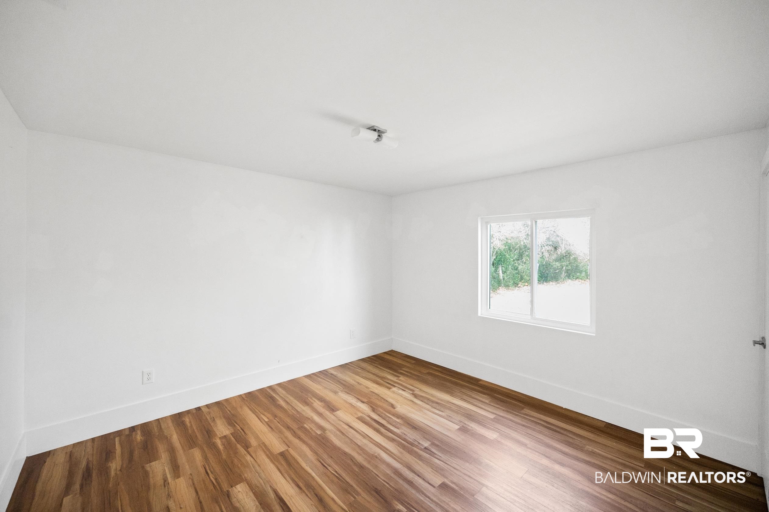 24663 Chestnut Street Elberta, AL 36530 - Photo 6 of 22 Bright interior room featuring wood-finish flooring, white walls, and a white trim baseboard