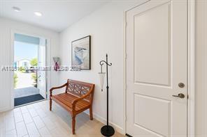 14531 Bretton Woods Trace Delray Beach, FL 33446 - Photo 6 of 57 a view of a hallway with couches and potted plant with view of bathroom