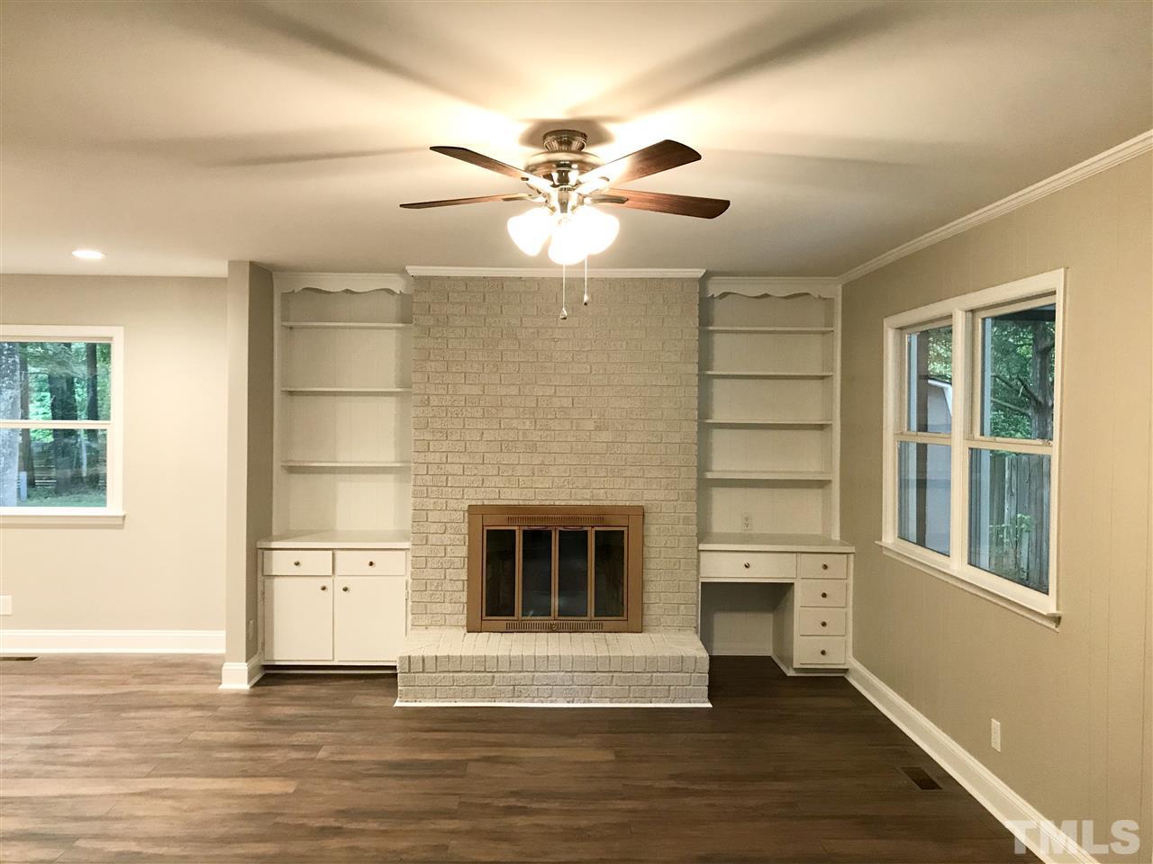 932 Bluestone Road Durham, NC 27713 - Photo 5 of 18 Cozy family room with wood burning fireplace and bookshelves/storage. Side entry to carport.