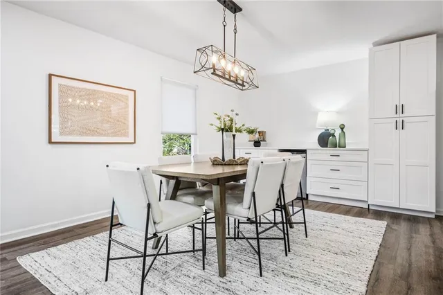 a dining room with wooden floor a chandelier a wooden table and chairs