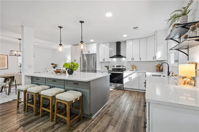 a kitchen with kitchen island granite countertop a sink a counter space and stainless steel appliances