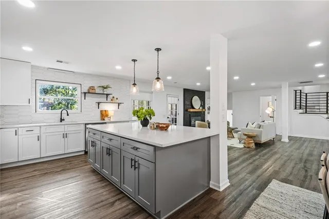 a kitchen with kitchen island white cabinets and stainless steel appliances