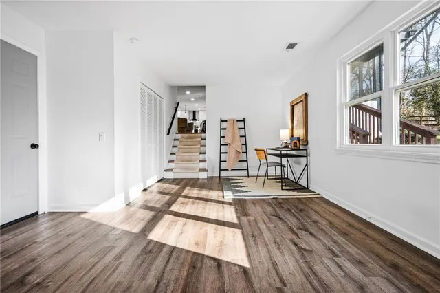 a view of a room with wooden floor and furniture