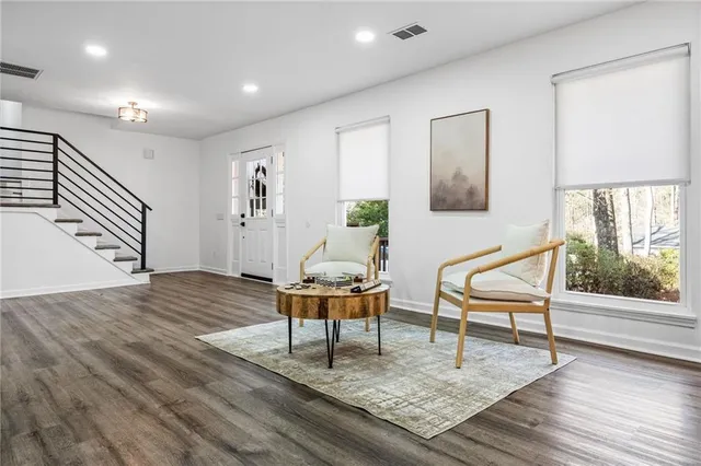 a living room with furniture and a wooden floor