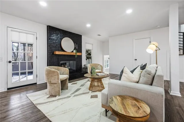 a living room with furniture a window and wooden floor