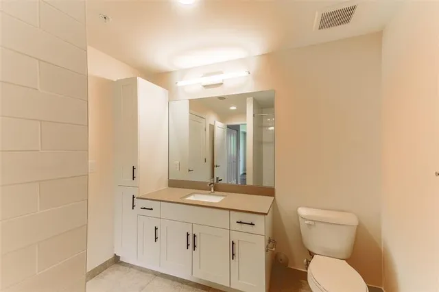 a bathroom with a toilet a sink a mirror and a shower