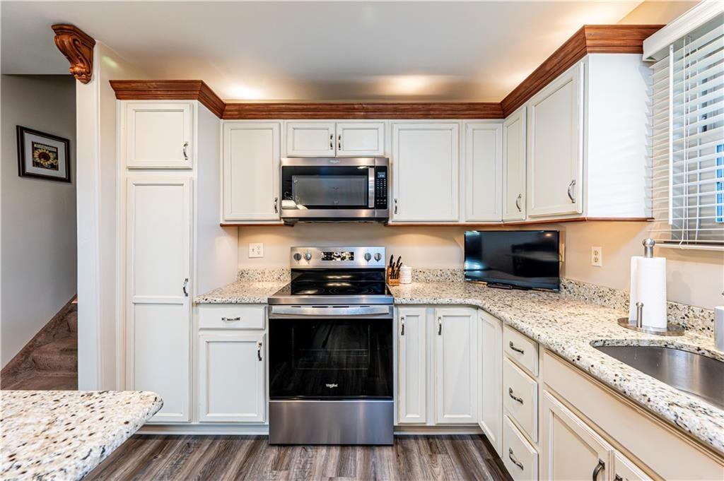 108 Stewart Road Derry, PA 15627 - Photo 15 of 30 a kitchen with granite countertop a sink a stove top oven and cabinetry