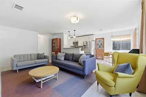 a living room with furniture a rug and a kitchen view