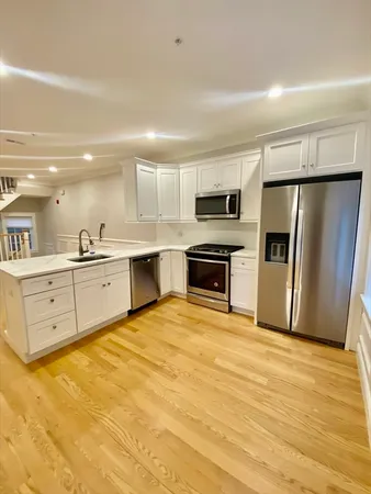 a large kitchen with cabinets stainless steel appliances and a counter space