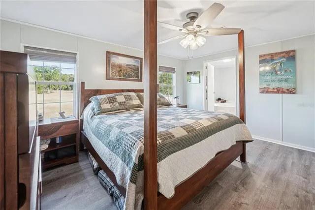 a spacious bedroom with a bed and wooden floor