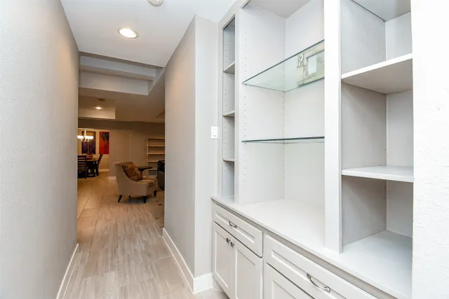 a walk in closet with view of living room