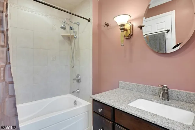 a bathroom with a granite countertop shower a mirror and a sink