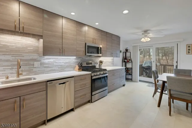 a kitchen with stainless steel appliances granite countertop a sink and stove top oven