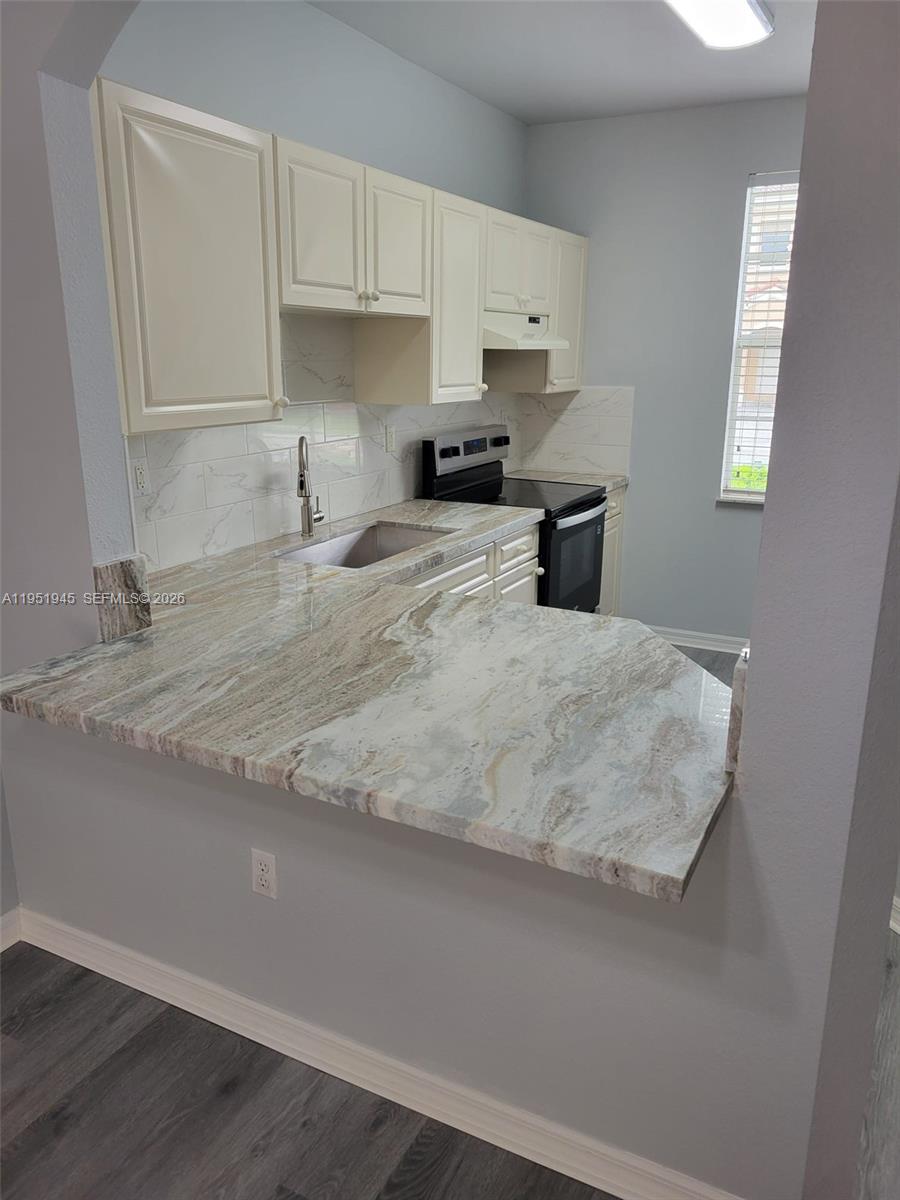 751 Southeast 2nd Street Homestead, FL 33030 - Photo 11 of 18 a kitchen with granite countertop white cabinets and stainless steel appliances