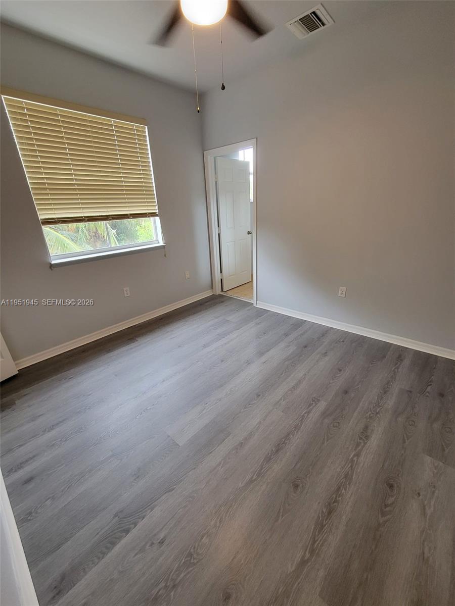 751 Southeast 2nd Street Homestead, FL 33030 - Photo 12 of 18 an empty room with wooden floor and windows