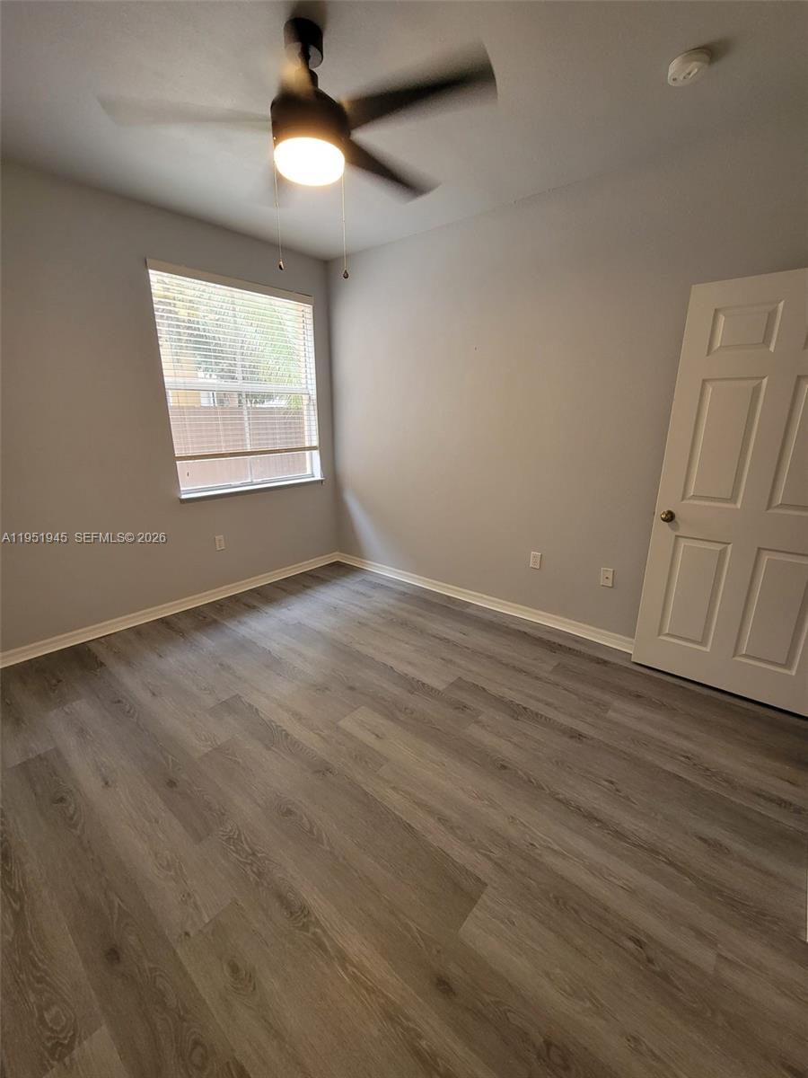 751 Southeast 2nd Street Homestead, FL 33030 - Photo 2 of 18 an empty room with wooden floor fan and windows