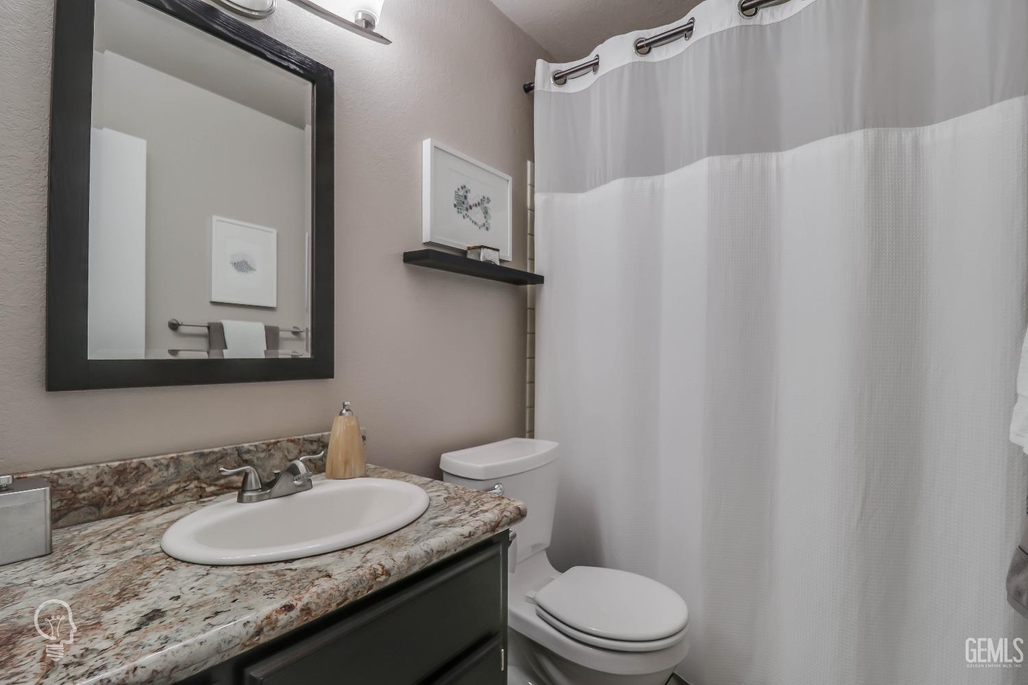 Undisclosed Address Bakersfield, CA 93311 - Photo 12 of 19 a bathroom with a granite countertop sink toilet and mirror
