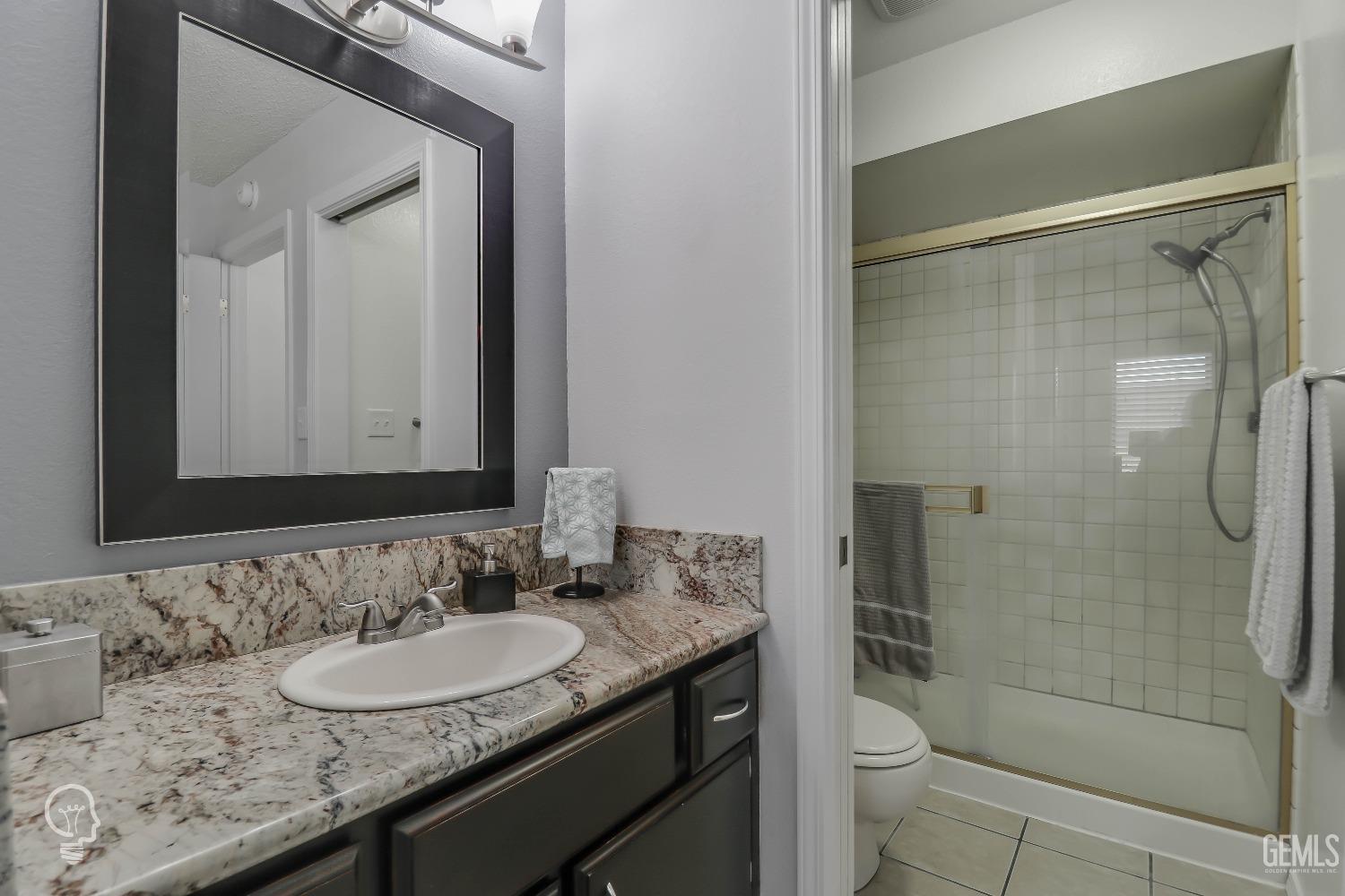 Undisclosed Address Bakersfield, CA 93311 - Photo 13 of 19 a bathroom with a granite countertop sink a toilet and shower