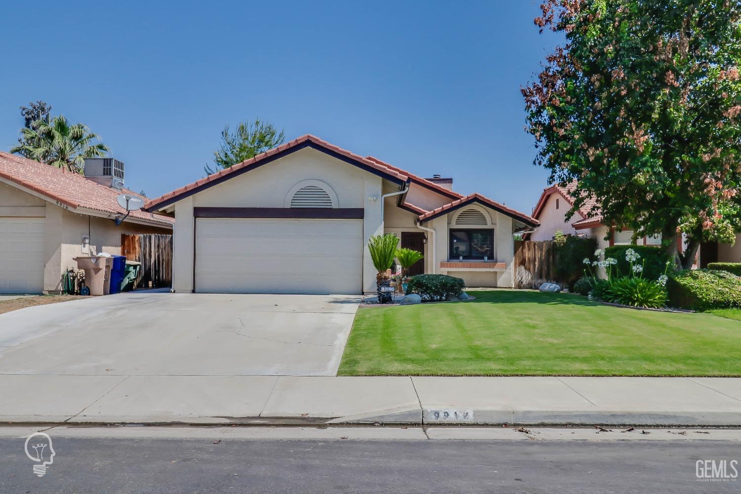 Undisclosed Address Bakersfield, CA 93311 - Photo 2 of 19 a front view of a house with a yard and garage