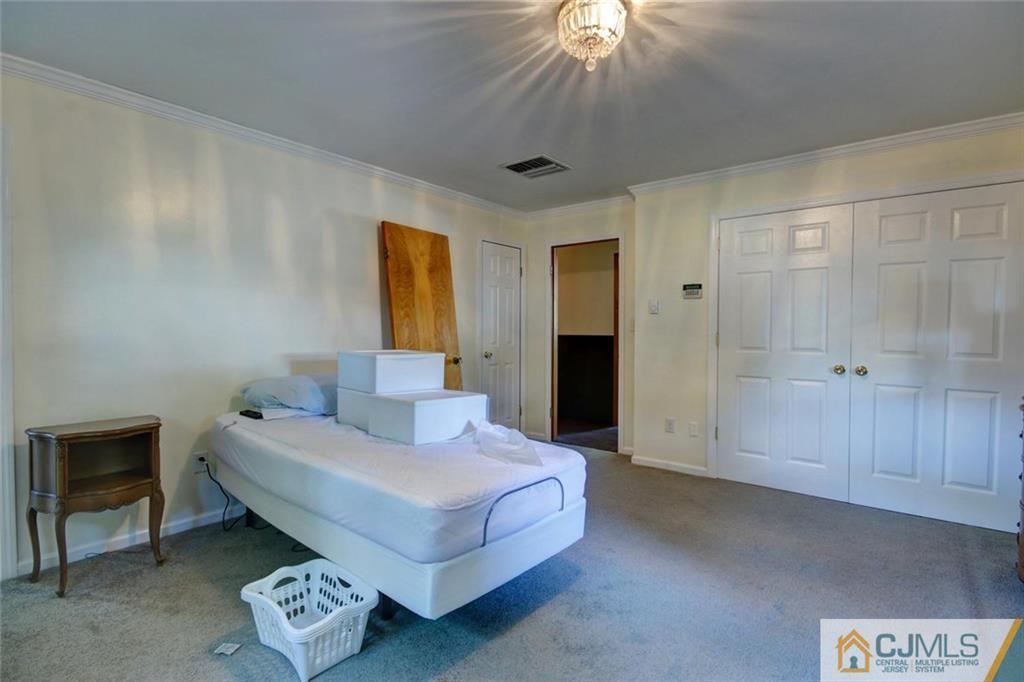 139 East Cliff Road Colonia, NJ 07067 - Photo 12 of 24 a spacious bedroom with a bed and a chandelier