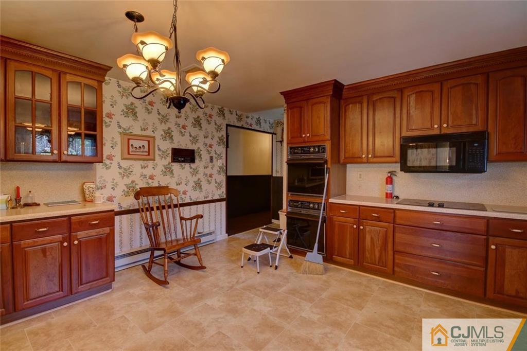 139 East Cliff Road Colonia, NJ 07067 - Photo 8 of 24 a kitchen with a sink chandelier and cabinets