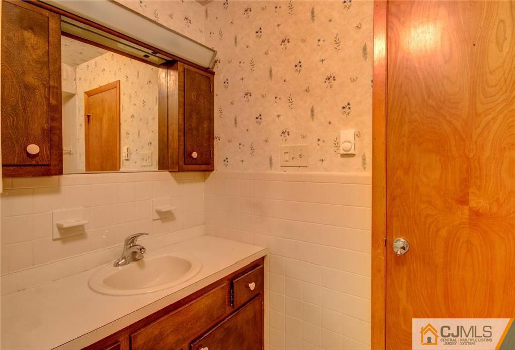 139 East Cliff Road Colonia, NJ 07067 - Photo 9 of 24 a bathroom with a sink a mirror and shower