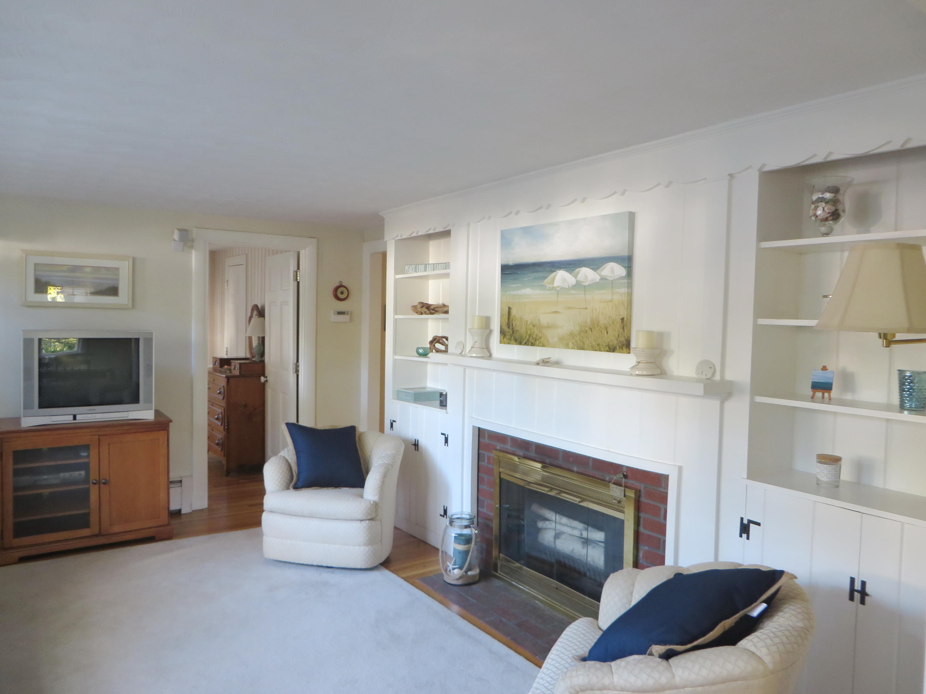229 Lower County Road West Harwich, MA 02671 - Photo 3 of 23 a living room with furniture and a fireplace