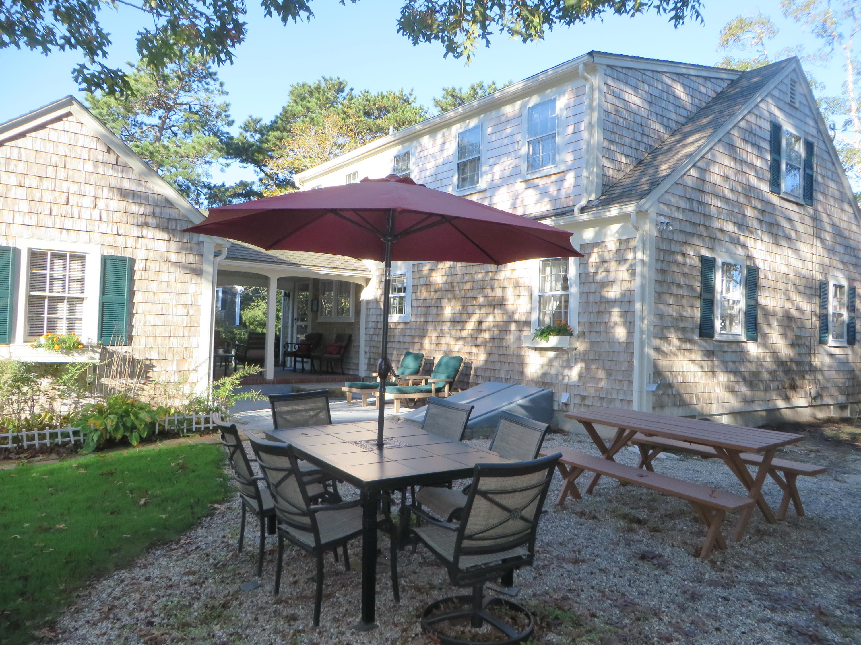 229 Lower County Road West Harwich, MA 02671 - Photo 10 of 23 a view of a patio with a table chairs and a yard