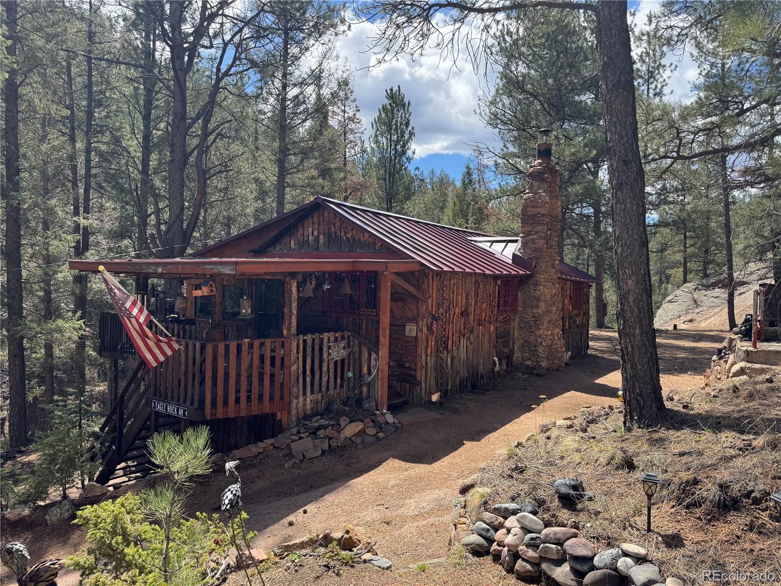 15751 South Elk Creek Road Pine, CO 80470 - Photo 3 of 34 a view of a house with a yard covered with snow in the forest