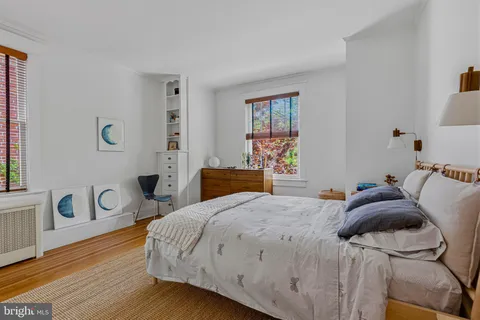 a bedroom with a bed and a table with wooden floor