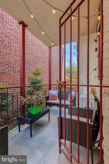 a view of a balcony with chairs and a potted plant
