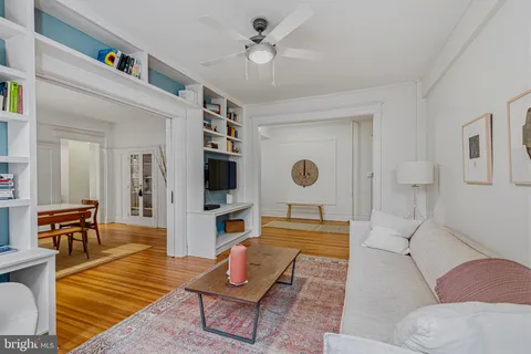 a living room with furniture a flat screen tv and kitchen view