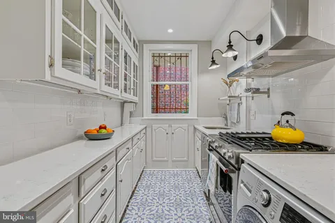 a kitchen with stainless steel appliances granite countertop a stove and cabinets