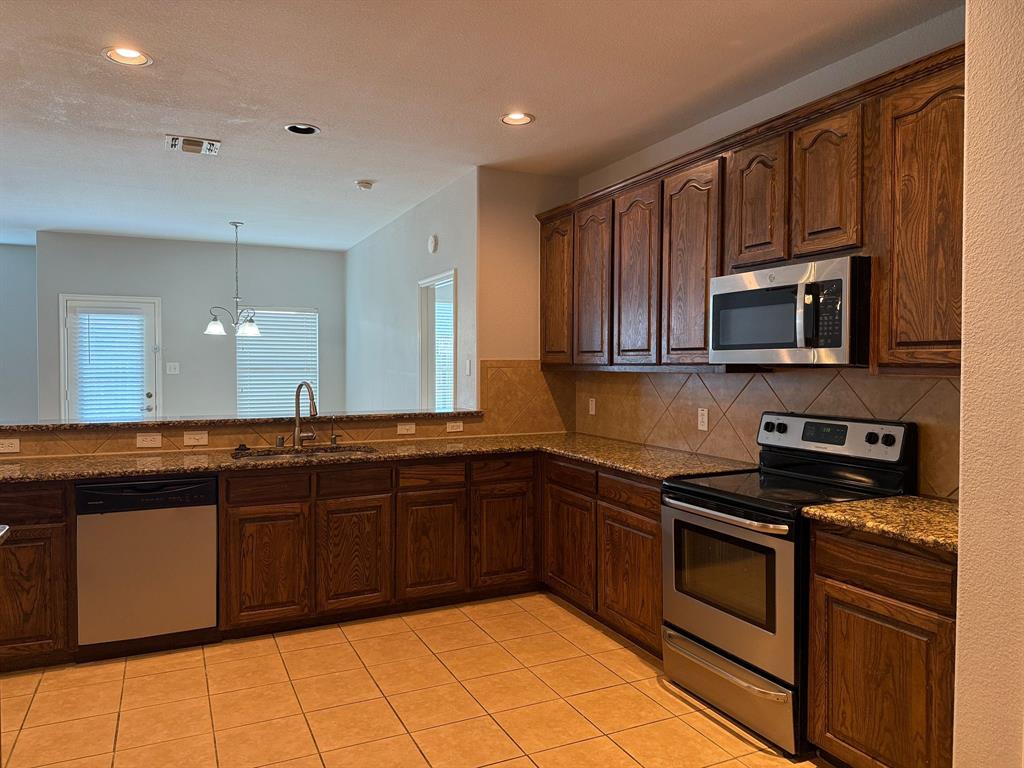 2047 Jack County Drive Forney, TX 75126 - Photo 6 of 20 a kitchen with stainless steel appliances granite countertop a stove top oven microwave and cabinets