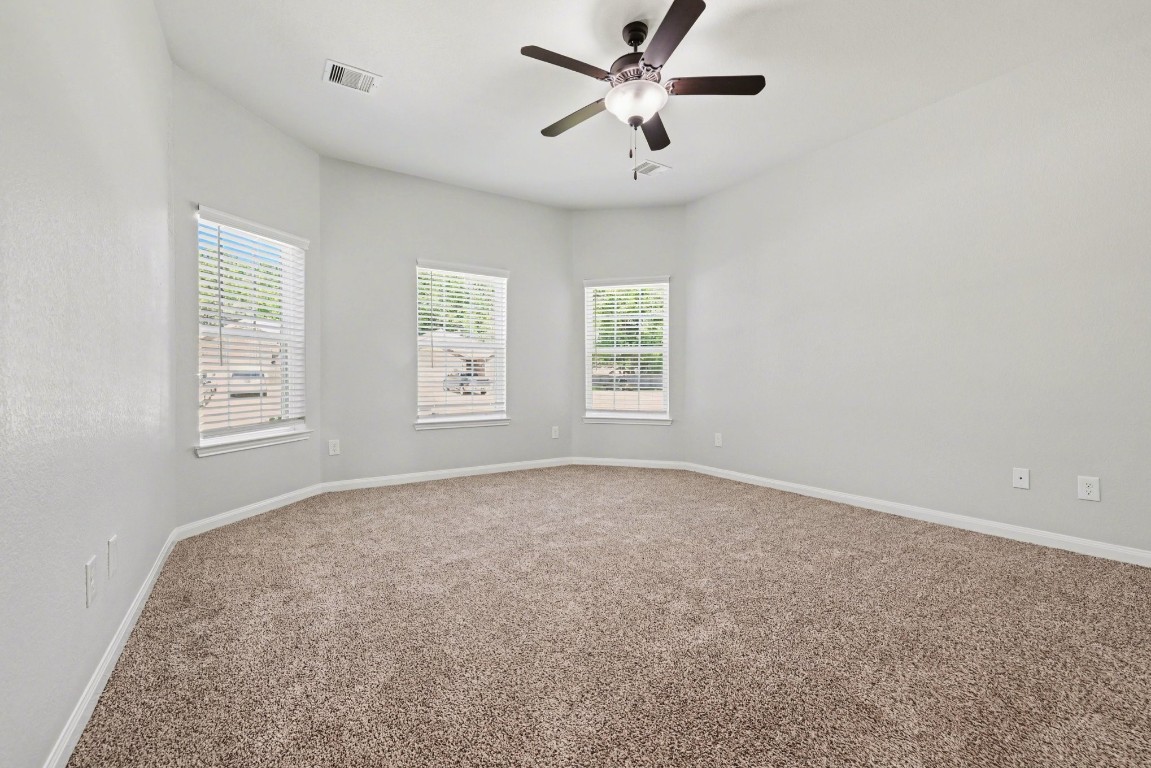 7722 Boulder Sunstone Lane Conroe, TX 77304 - Photo 16 of 25 an empty room with windows and fan