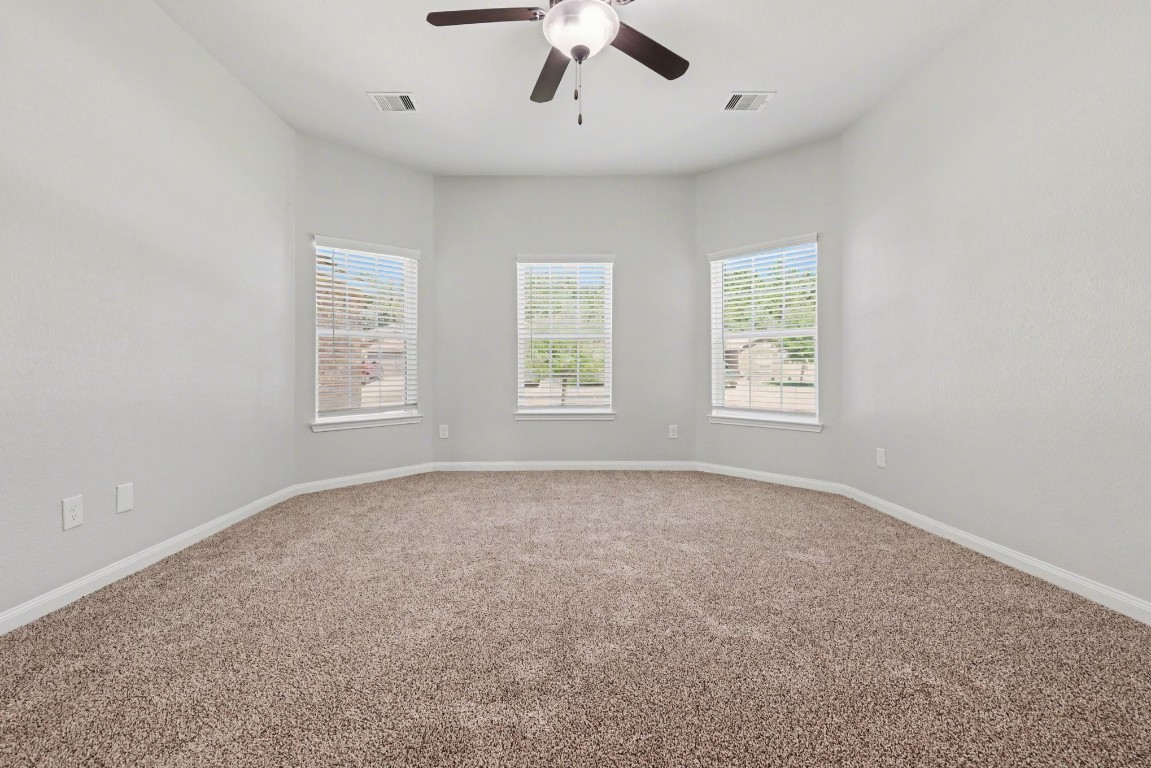 7722 Boulder Sunstone Lane Conroe, TX 77304 - Photo 17 of 25 an empty room with windows and fan