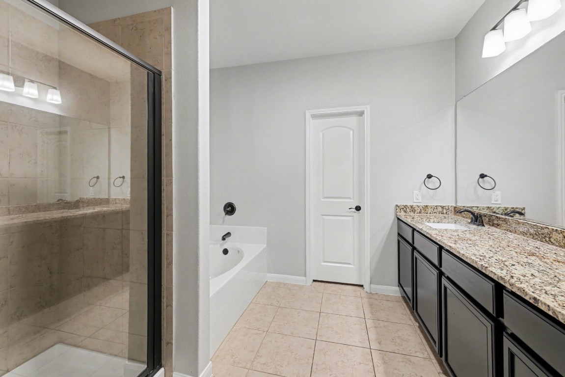 7722 Boulder Sunstone Lane Conroe, TX 77304 - Photo 18 of 25 a bathroom with a granite countertop sink and a mirror