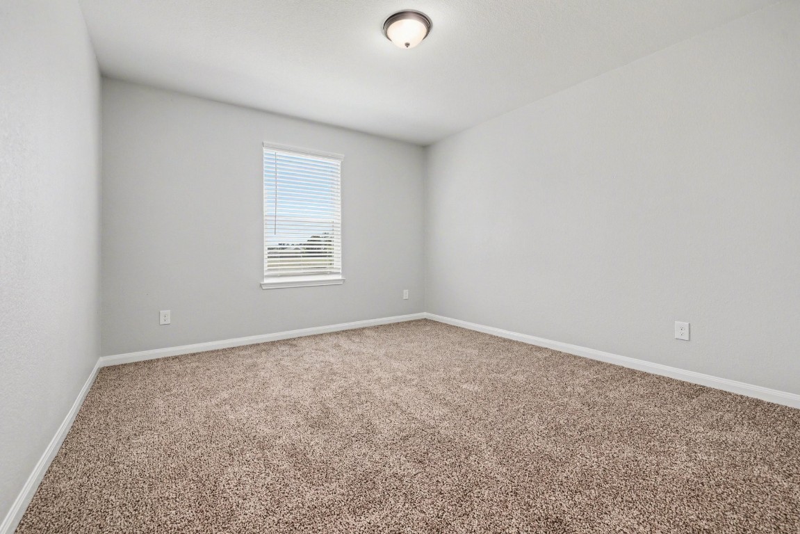 7722 Boulder Sunstone Lane Conroe, TX 77304 - Photo 19 of 25 an empty room with windows