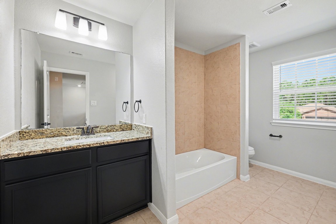 7722 Boulder Sunstone Lane Conroe, TX 77304 - Photo 22 of 25 a bathroom with a granite countertop sink tub and mirror