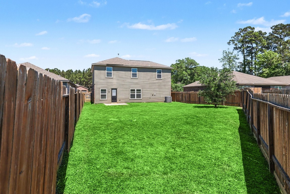 7722 Boulder Sunstone Lane Conroe, TX 77304 - Photo 25 of 25 a view of a house with backyard and porch